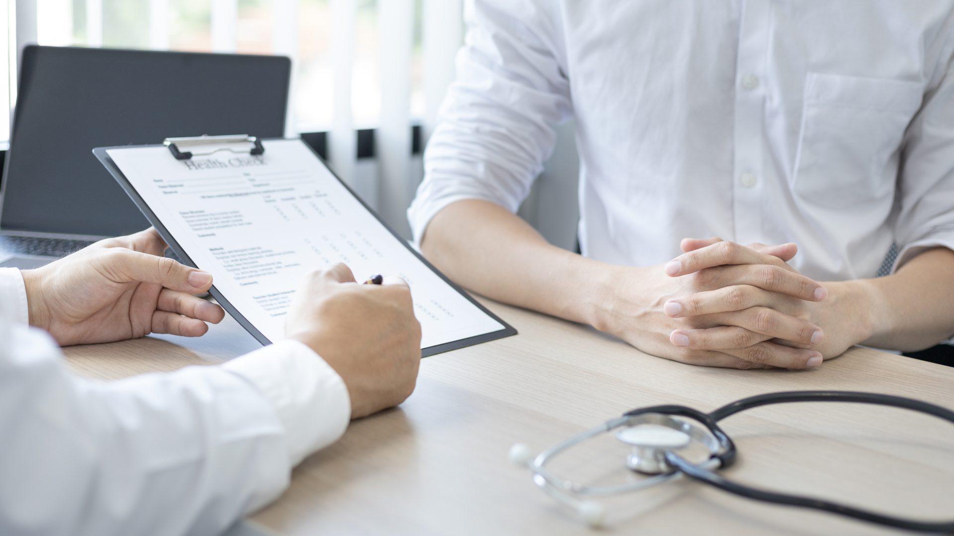 close up of a doctor holding a chart to a patient