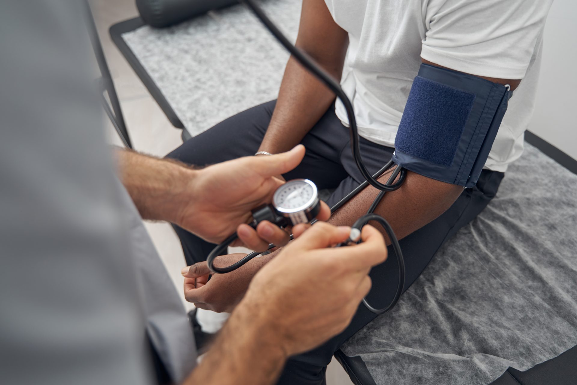 a close up of a doctor taking a blook pressure of a patient