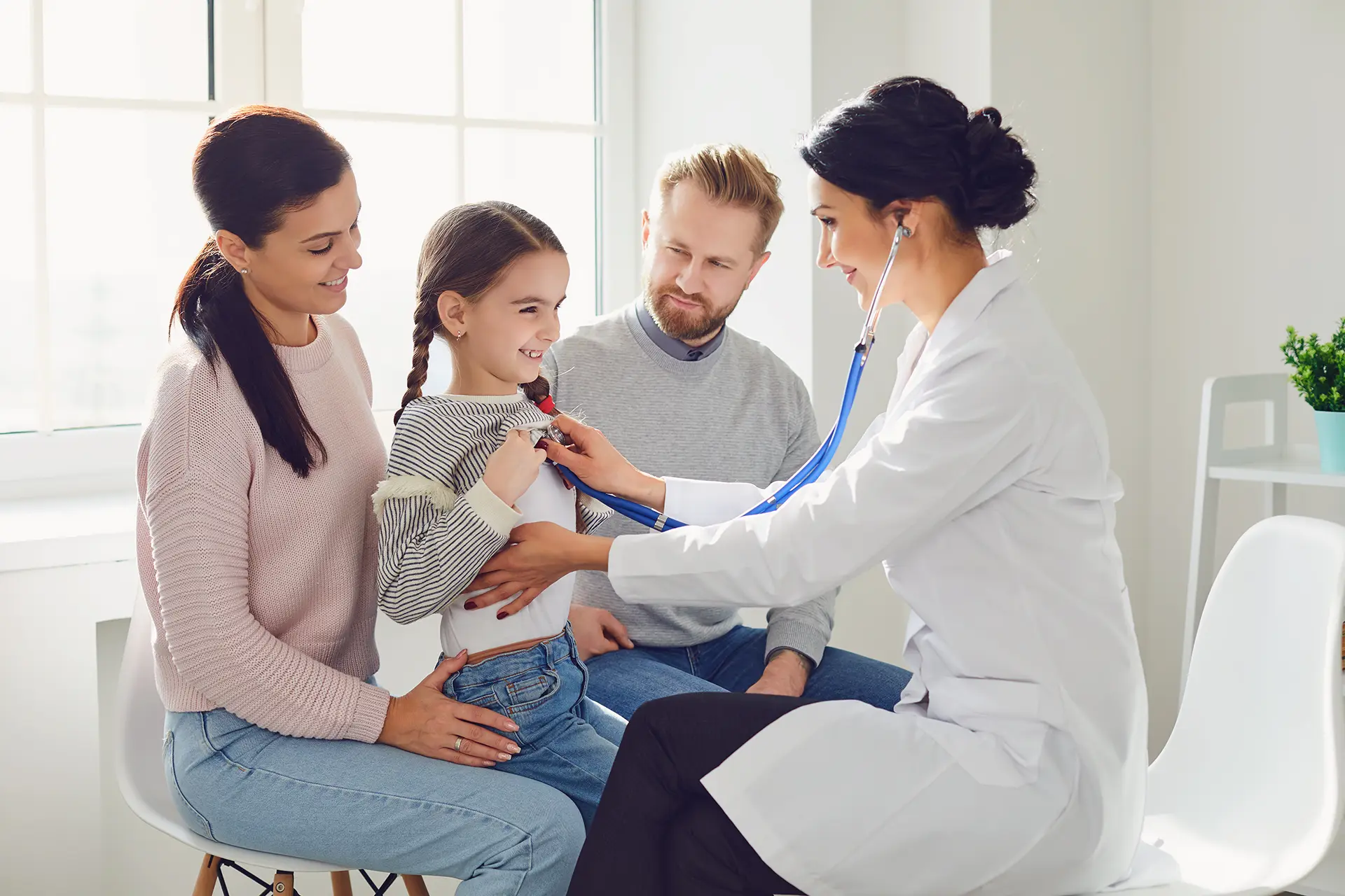 woman doctor checking the heart of a young girl